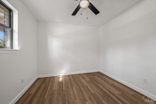 empty room with a ceiling fan, baseboards, and wood finished floors