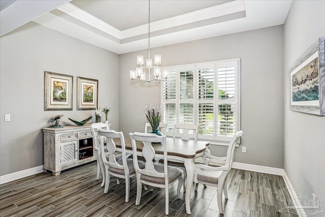 dining room featuring an inviting chandelier, baseboards, wood tiled floor, and a raised ceiling
