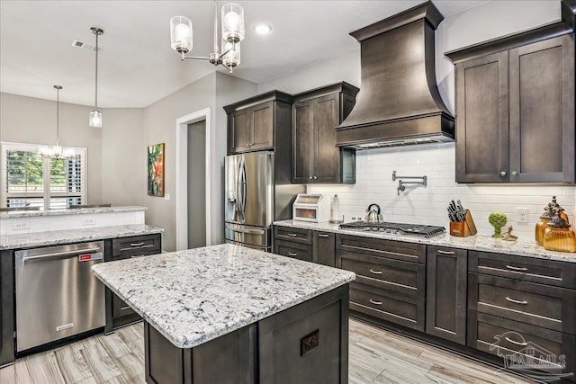 kitchen with custom exhaust hood, an inviting chandelier, visible vents, stainless steel appliances, and tasteful backsplash