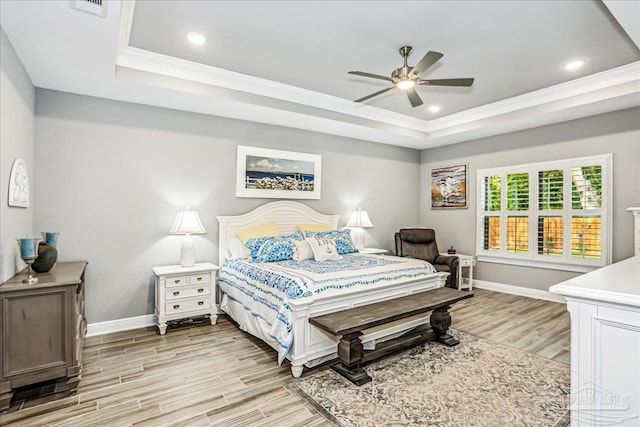 bedroom with baseboards, a tray ceiling, and crown molding