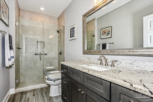 full bathroom featuring toilet, baseboards, vanity, and a shower stall