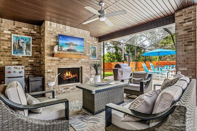 view of patio featuring ceiling fan, fence, and an outdoor living space with a fireplace