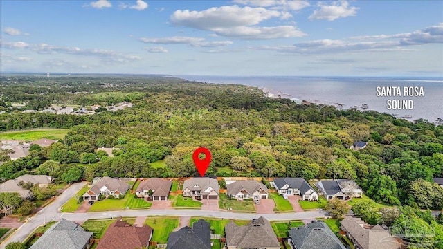 drone / aerial view with a water view, a view of trees, and a residential view