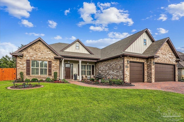 craftsman inspired home featuring board and batten siding, brick siding, fence, an attached garage, and a front lawn