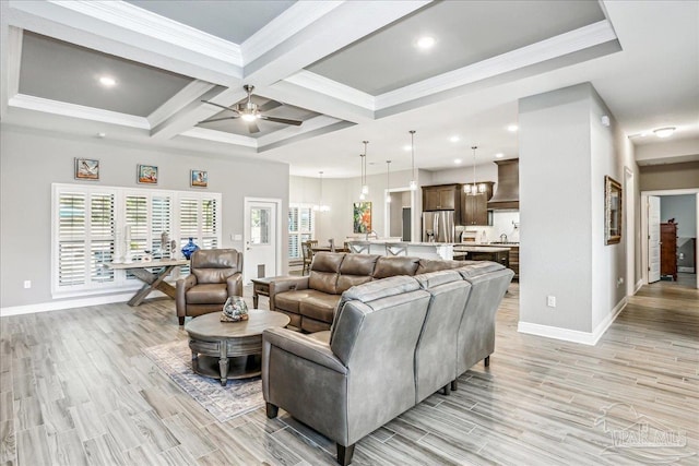 living area featuring baseboards, beamed ceiling, light wood-style floors, and a ceiling fan