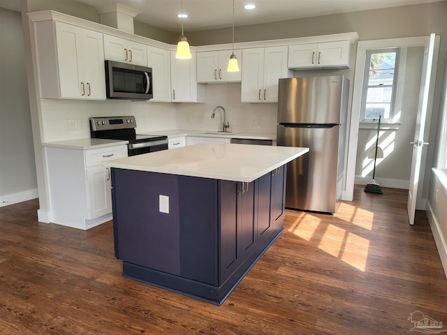 kitchen with appliances with stainless steel finishes, dark hardwood / wood-style flooring, and white cabinets