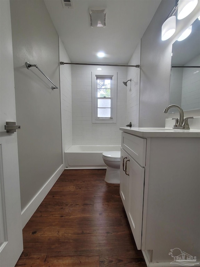 full bathroom with wood-type flooring, toilet, vanity, and tiled shower / bath