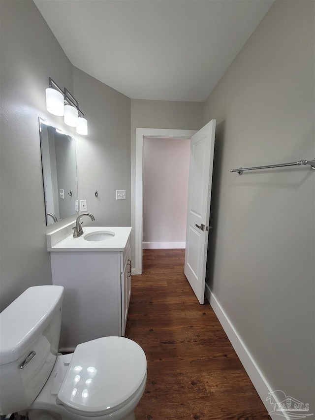 bathroom with vanity, toilet, and hardwood / wood-style flooring