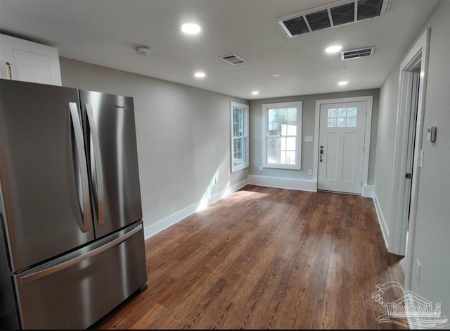 kitchen featuring stainless steel refrigerator, dark hardwood / wood-style flooring, and white cabinetry