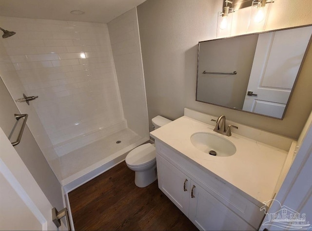 bathroom featuring vanity, wood-type flooring, walk in shower, and toilet