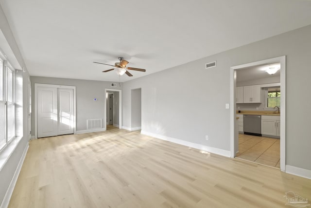 interior space featuring ceiling fan, light wood-type flooring, and sink