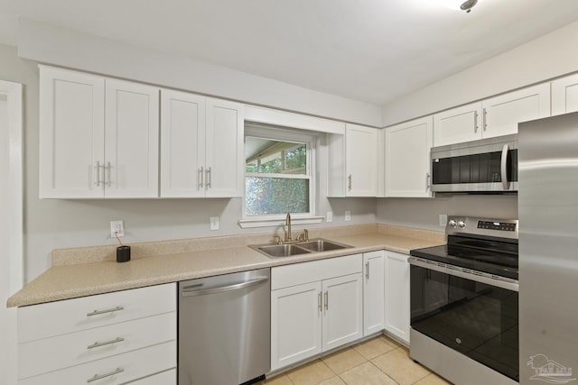 kitchen featuring white cabinets, light tile patterned floors, sink, and appliances with stainless steel finishes