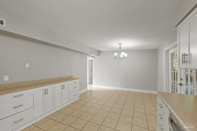 interior space featuring a chandelier, pendant lighting, light tile patterned floors, and white cabinetry