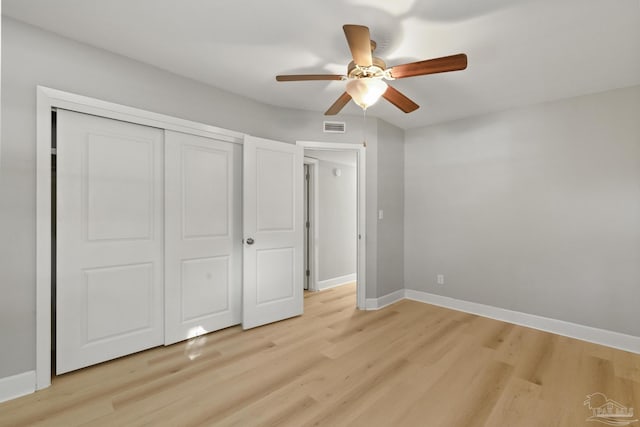 unfurnished bedroom featuring ceiling fan, a closet, and light wood-type flooring