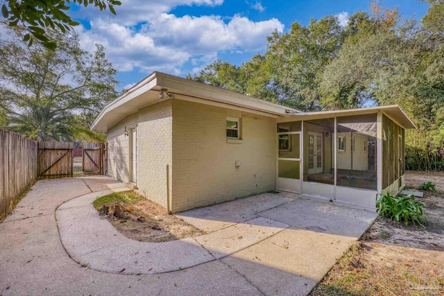 rear view of house featuring a patio area and a sunroom