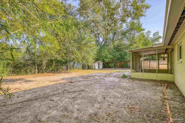 view of yard featuring a sunroom and a shed