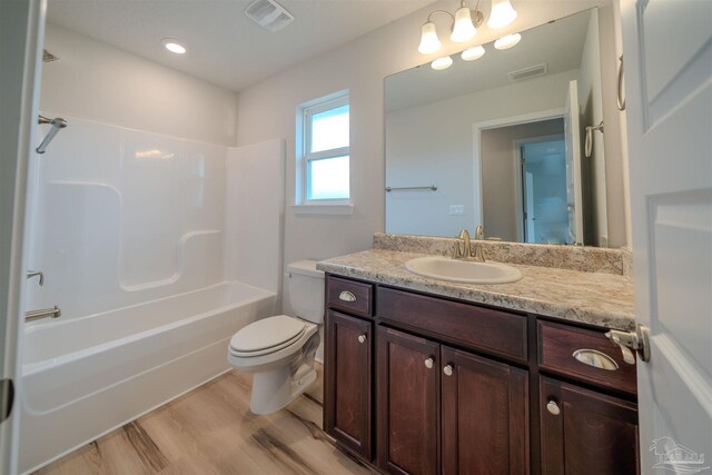 full bathroom featuring vanity, hardwood / wood-style floors, shower / tub combination, and toilet