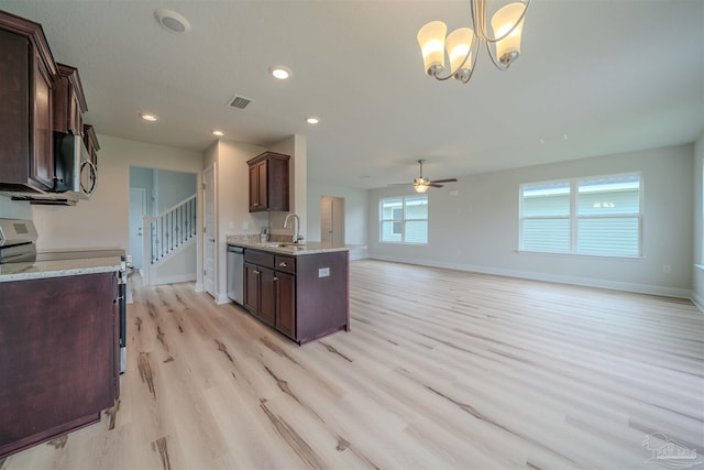 kitchen featuring sink, ceiling fan with notable chandelier, stainless steel appliances, light hardwood / wood-style floors, and decorative light fixtures