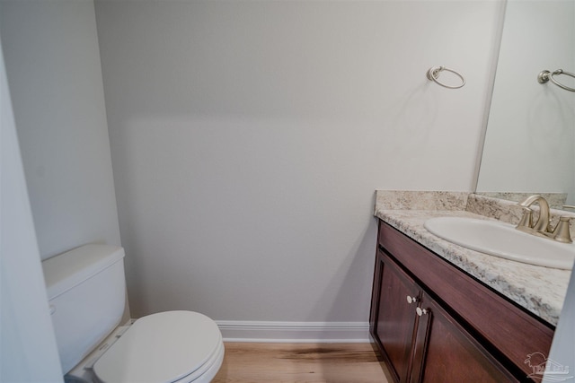 bathroom featuring vanity, hardwood / wood-style flooring, and toilet