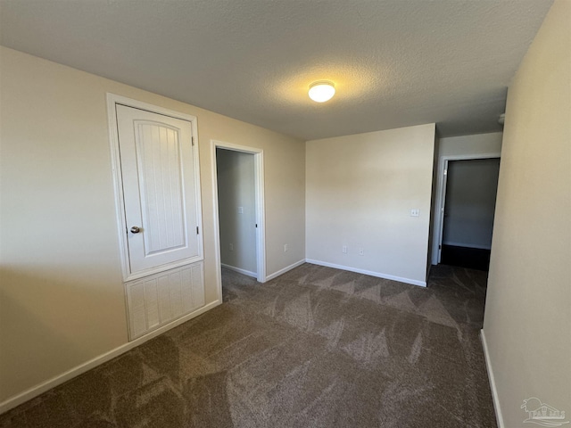 carpeted spare room featuring baseboards, a textured ceiling, and visible vents