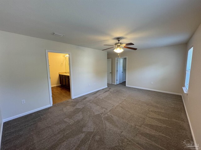 carpeted spare room featuring a ceiling fan and baseboards