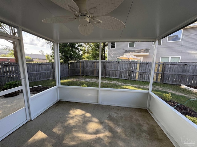 unfurnished sunroom featuring ceiling fan and a healthy amount of sunlight