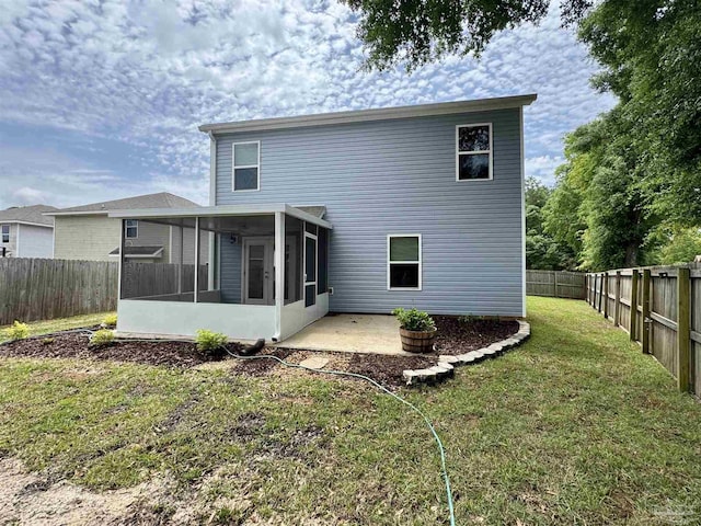 back of house featuring a lawn, a patio, a fenced backyard, and a sunroom