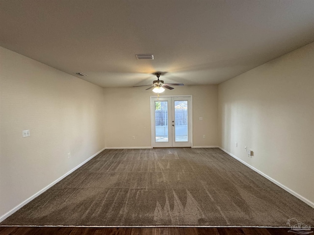 carpeted spare room featuring baseboards, a ceiling fan, and visible vents