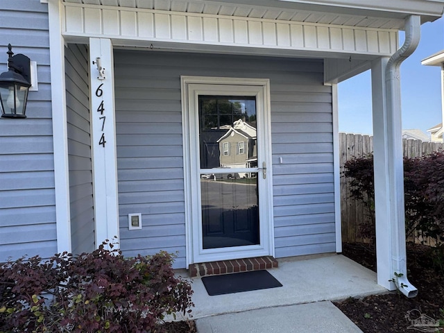 view of exterior entry with fence