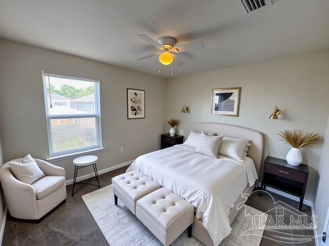 bedroom featuring carpet floors, baseboards, visible vents, and ceiling fan