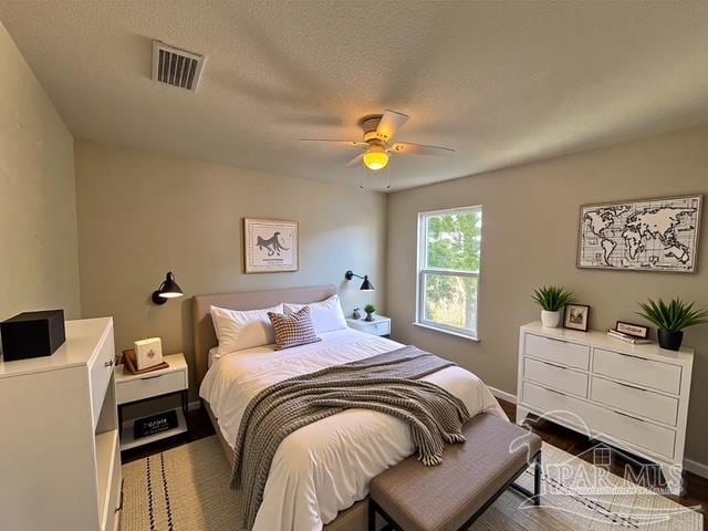 bedroom featuring baseboards, ceiling fan, and visible vents