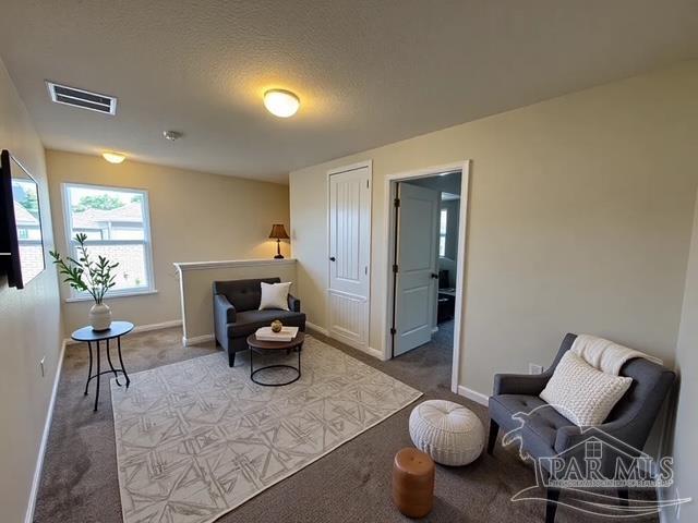 sitting room with visible vents, baseboards, and carpet floors