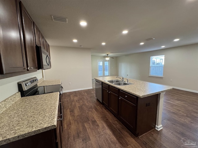 kitchen with visible vents, dark brown cabinetry, dark wood-type flooring, a sink, and appliances with stainless steel finishes