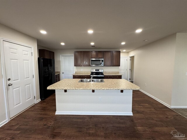 kitchen with dark brown cabinets, appliances with stainless steel finishes, a sink, and recessed lighting