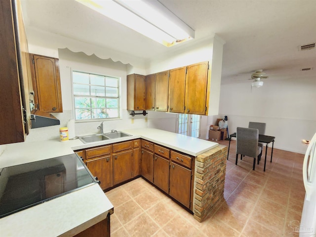 kitchen featuring light tile patterned floors, kitchen peninsula, sink, and electric range