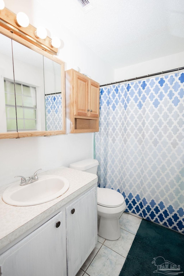 bathroom featuring vanity, tile patterned flooring, and toilet