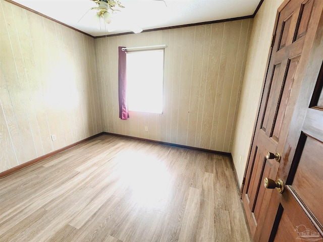 empty room with ornamental molding, ceiling fan, and light wood-type flooring