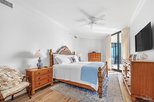 bedroom featuring visible vents, light wood-style floors, access to outside, and ornamental molding