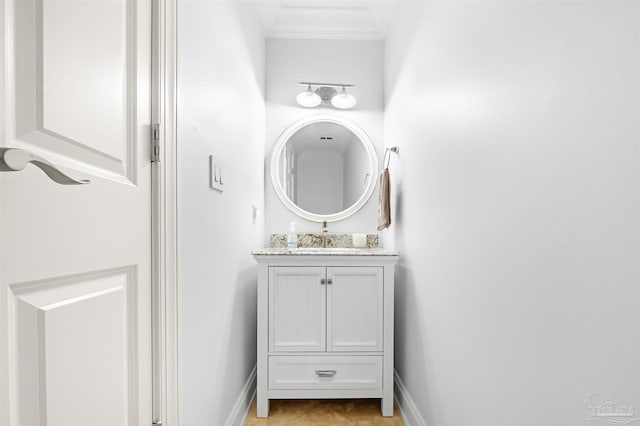 bathroom with crown molding, baseboards, and vanity