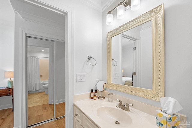 ensuite bathroom featuring shower / bath combo with shower curtain, connected bathroom, vanity, wood finished floors, and crown molding