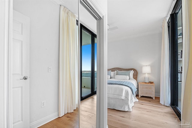 bedroom featuring baseboards, light wood-style floors, and access to outside