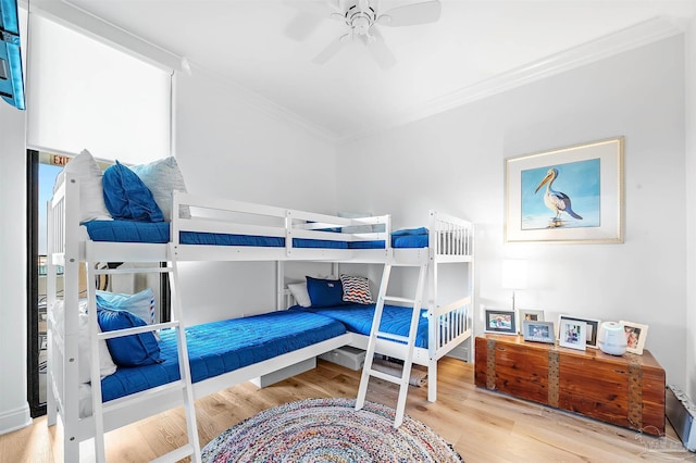 bedroom with a ceiling fan, wood finished floors, and ornamental molding