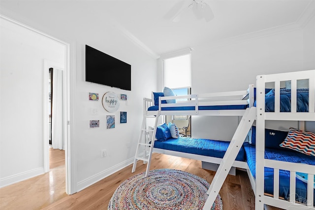 bedroom featuring crown molding, baseboards, and wood finished floors