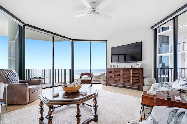 living area featuring expansive windows and a ceiling fan