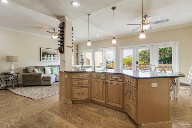 kitchen with light hardwood / wood-style floors, a textured ceiling, and ceiling fan