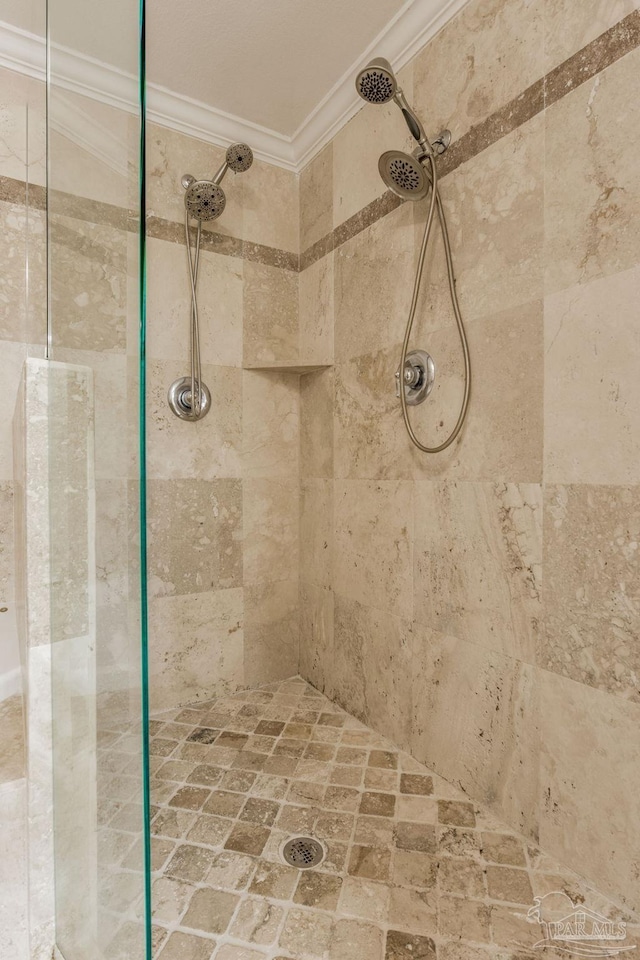 bathroom with a tile shower and ornamental molding