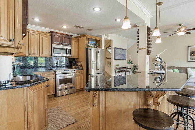 kitchen with appliances with stainless steel finishes, sink, ornamental molding, and a textured ceiling