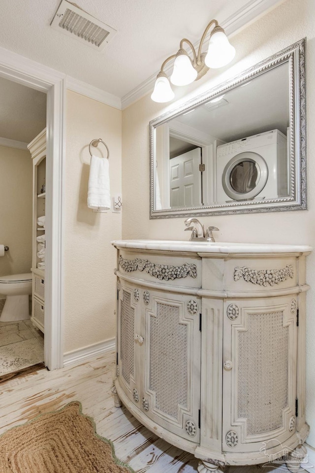 bathroom featuring toilet, vanity, hardwood / wood-style floors, and ornamental molding