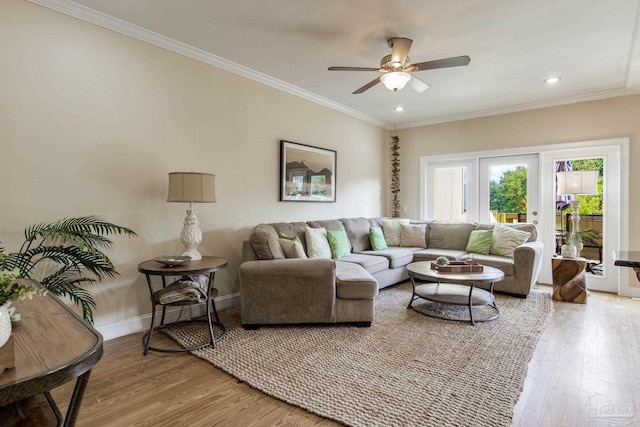 living room with wood-type flooring, ceiling fan, and crown molding