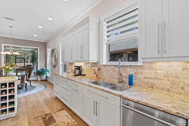 kitchen featuring a sink, visible vents, ornamental molding, dishwasher, and tasteful backsplash